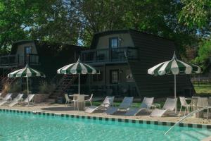 a group of chairs and umbrellas next to a pool at Petit Cowboy in New Braunfels