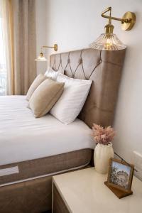 a bed with white pillows and a lamp on a table at NUR Apartment in Dobra Voda +26 photos