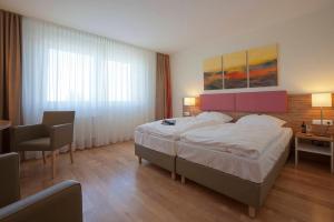 ein Hotelzimmer mit einem großen Bett und einem Schreibtisch in der Unterkunft Hotel am Markt Garni - Aegidienberg in Bad Honnef am Rhein