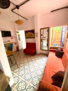a living room with a red couch and a mirror at Pinheiros Hostel & Food in São Paulo