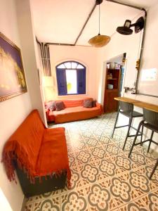 a living room with an orange couch and a table at Pinheiros Hostel & Food in São Paulo