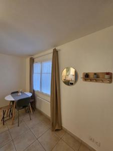 a room with a table and a mirror and a window at Eden lodge Chessy - 10min Disneyland - Parking in Chessy +10 photos