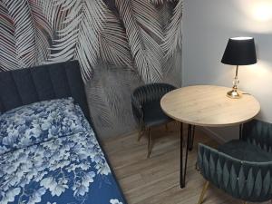 a bedroom with a bed and a table and chairs at Urban Palace bezpłatne miejsce postojowe in Wrocław