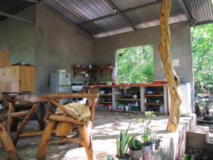 a room with a wooden chair and a kitchen at Cielo y Tierra in Santa Cruz