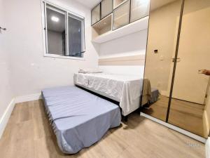 a small room with two beds and a mirror at Xingu Reserva Ipanema in Porto Alegre