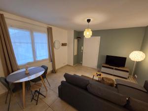 a living room with a couch and a table at Eden lodge Chessy - 10min Disneyland - Parking in Chessy