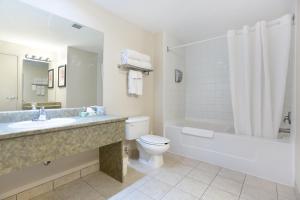 a bathroom with a sink and a toilet and a bath tub at Lakeview Inns & Suites - Okotoks in Okotoks +29 photos