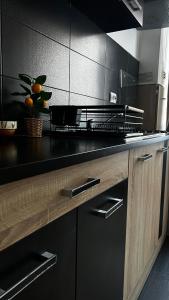 a kitchen with a black counter with oranges on it at SCC2 Apartments in Cluj-Napoca