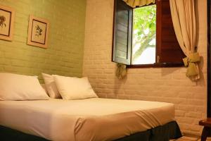 a bed in a bedroom with a window at Hotel Casa Grande Gravatá in Gravatá