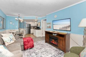 a living room with a tv and a fireplace at Amazing Oceanfront Home HS 4th Floor in Myrtle Beach