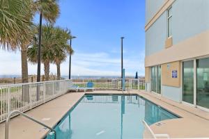 a swimming pool with palm trees and a building at Amazing Oceanfront Home HS 4th Floor in Myrtle Beach
