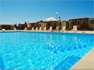 a swimming pool with blue water and bottles in it at Mobile Homes Peroš in Zaton