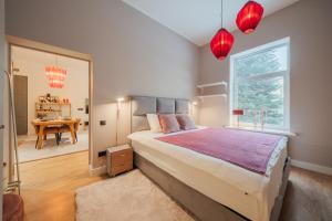 a bedroom with a large bed and a table at Rozā Dāvids in Liepāja