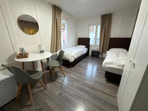 a hotel room with two beds and a table and chairs at SleepandGo in Zurich