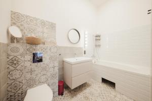 a white bathroom with a toilet and a sink at Rozā Dāvids in Liepāja +31 photos