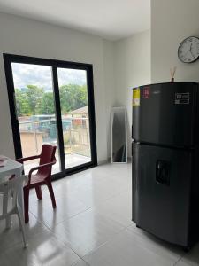 a kitchen with a black refrigerator and a table and a clock at Apartaestudio amoblado 303 Edificio Buenos Aires Sincelejo in Sincelejo