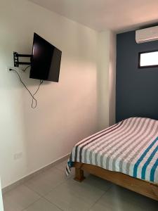 a bedroom with a bed and a tv on the wall at Apartaestudio amoblado 303 Edificio Buenos Aires Sincelejo in Sincelejo