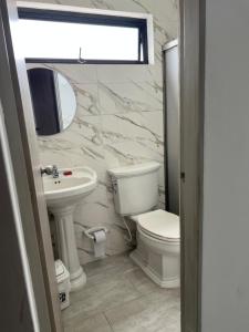 a bathroom with a toilet and a sink and a mirror at Apartaestudio amoblado 303 Edificio Buenos Aires Sincelejo in Sincelejo