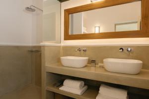 a bathroom with two sinks and a mirror at Ocean Caldera View Villa by Dalmyra Estate in Imerovigli +15 photos