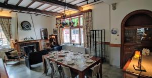 a dining room with a table and a fireplace at La Porte Noire in Courcelles