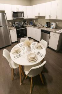 a kitchen with a white table with plates and glasses at Blackbeam Suite in Des Moines +6 photos