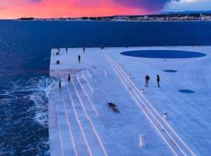 a group of people walking on a pier over the water at Holiday House Franov in Zadar