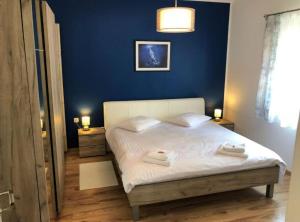 a bedroom with a white bed with a blue wall at Holiday House Franov in Zadar +21 photos