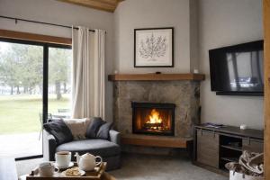 a living room with a fireplace and a tv at Lodge Condo 031 in Black Butte Ranch