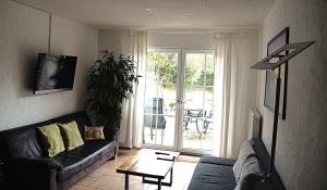 a living room with a couch and a table at Wellness Apartments Sophienhöhe AM TEICH in Mechernich