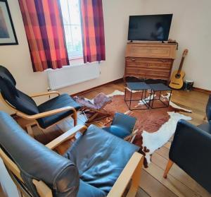 a living room with a couch and chairs and a rug at La Porte Noire in Courcelles