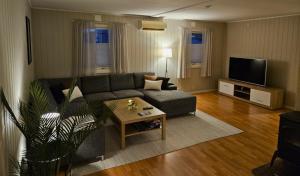 a living room with a couch and a tv at Cozy House in Tromsø - Near City Center, Ideal for Families & Groups in Tromsø