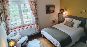 a small bedroom with a bed and a window at La Porte Noire in Courcelles