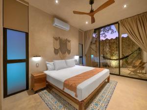 a bedroom with a large bed and large windows at suite tropical en oasis tropical del centro de Mérida in Mérida