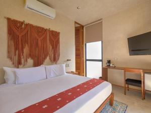 a bedroom with a large bed and a television at suite tropical en oasis tropical del centro de Mérida in Mérida
