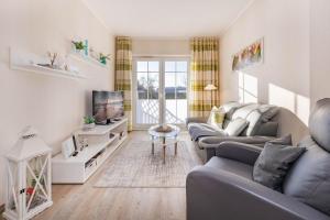 a living room with two couches and a tv at Fewo Kleine Auszeit 02 in Koserow