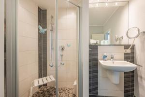 a bathroom with a shower and a sink at Fewo Kleine Auszeit 02 in Koserow +4 photos