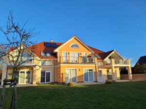 a large yellow house with a large yard at Fewo Kleine Auszeit 02 in Koserow