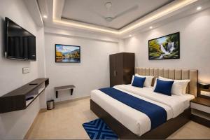 a bedroom with a large bed and a television at The Nest Kashi in Varanasi