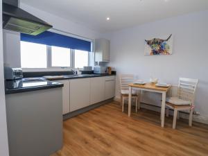 a kitchen with white cabinets and a table with chairs at Genesis in Richmond