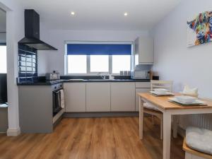 a kitchen with white cabinets and a wooden table at Genesis in Richmond +4 photos