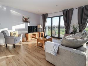 a living room with a couch and chairs and a tv at Fleetwood in Richmond +10 photos