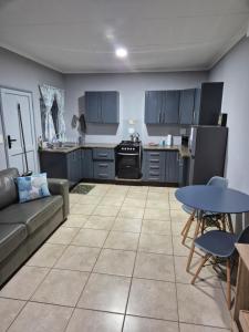 a living room with a couch and a kitchen at Wattlewood Cabins in Piet Retief