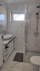 a bathroom with a shower and a sink and a toilet at Villa Vanília in Keszthely