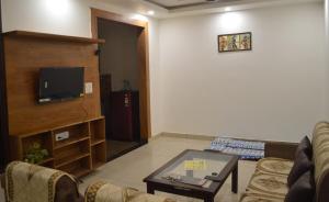 a living room with a couch and a tv at Ananta 1BHK in Birbhaddar