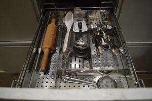 a metal strainer in a dish rack with utensils at Ananta 1BHK in Birbhaddar