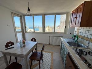 a kitchen with a table and a sink and some windows at L'atmosfera in Brindisi