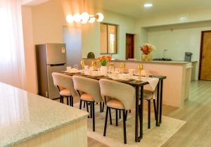 a dining room with a table with chairs and a refrigerator at Rupa villas in Eldoret