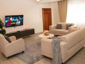 a living room with couches and a flat screen tv at Rupa villas in Eldoret
