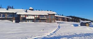 ein Gebäude im Schnee mit einer Skipiste in der Unterkunft Synnseter in Nord Torpa