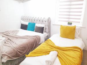 two beds in a room with a yellow blanket at Exclusive Apartment in Newcastle upon Tyne